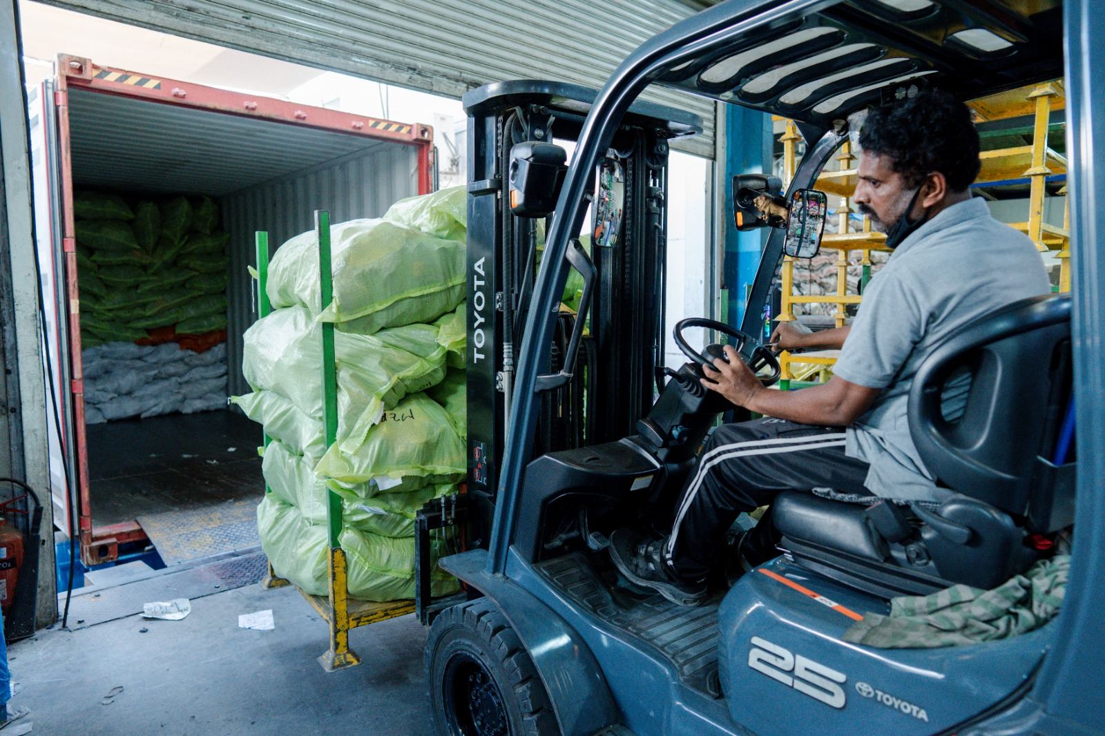 Forklift unloading bales from a container